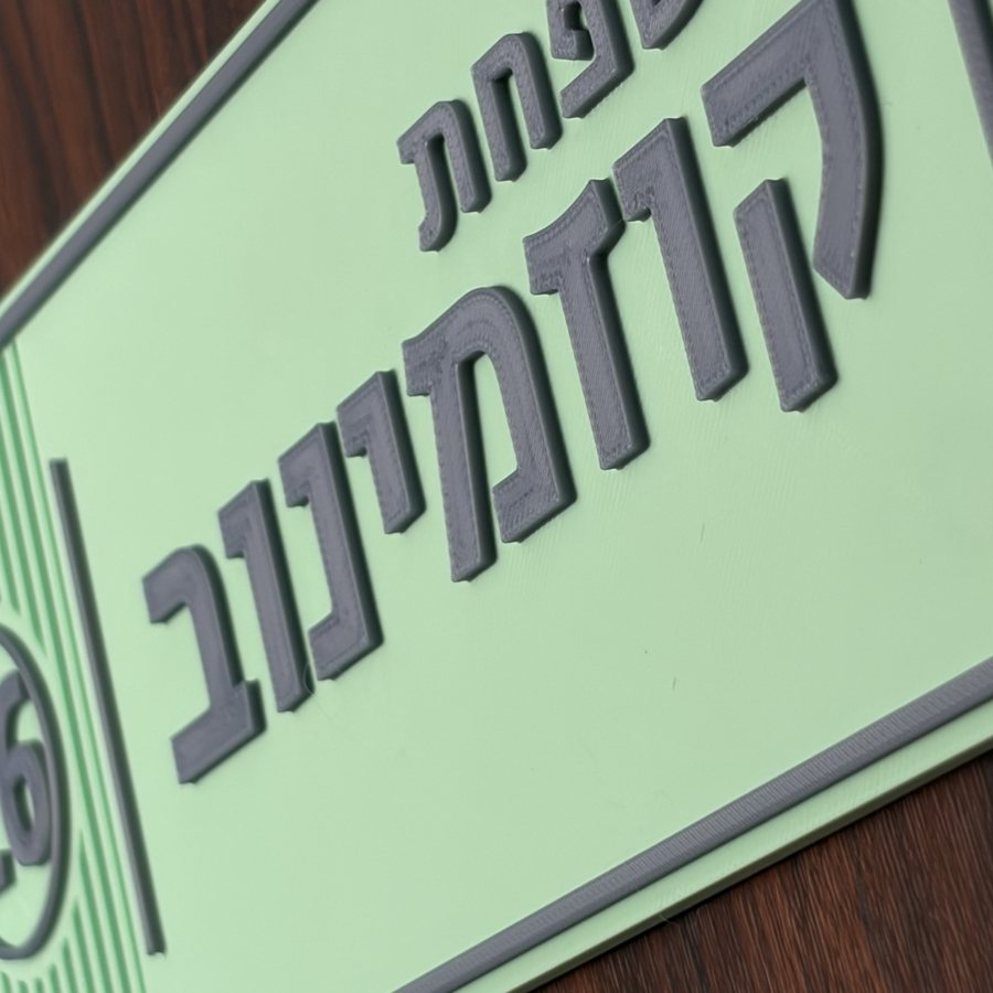 אותיות אפורות מנוגדות על שלט במנטה — הדפסה דו-צבעית