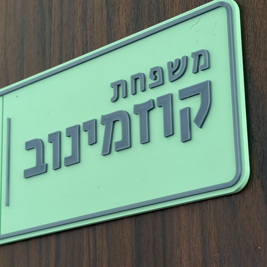 השלט מותקן על דלת כניסה מעץ